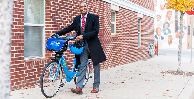 IBX Employee Walking An Indego Bike