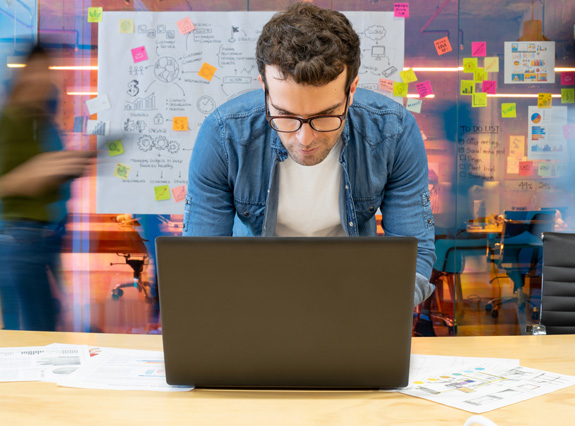 A person is working at a computer in a busy office.